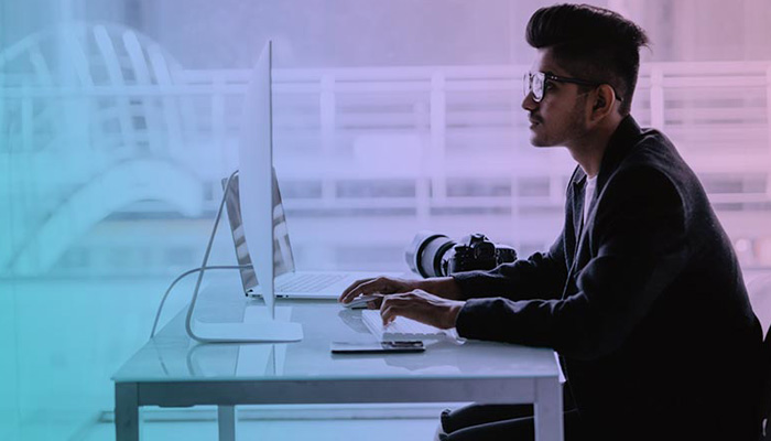 A man attending a virtual event sitting in front of laptop.